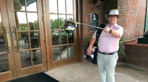 Photo of Justin with golf club and golf bag