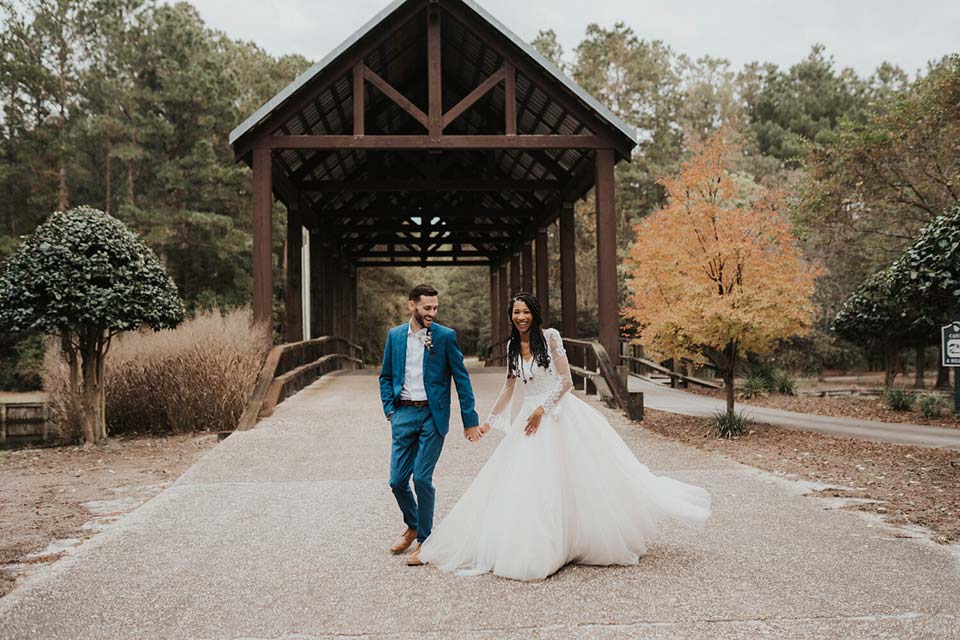 Photo of bride and groom in front of a covered bridge