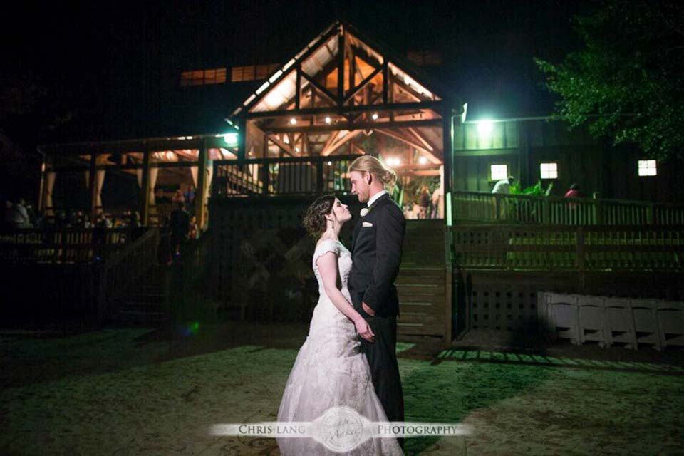 Photo of bride and groom outside of the River Lodge at night
