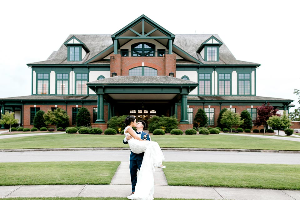 Photo of just married couple kissing in front of River landing Entrance