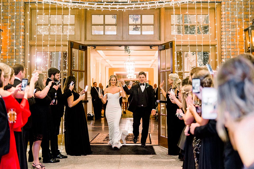 Photo of a bride and groom walking through doors going outside