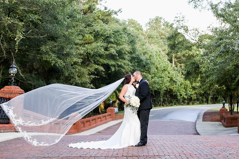 Photo of bride and groom kissing outside