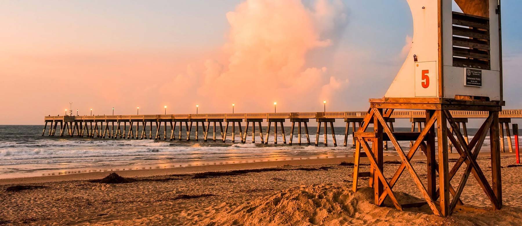 Photo of pier on beach at sunrise