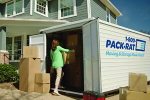 Photo of a woman putting a box into a moving container