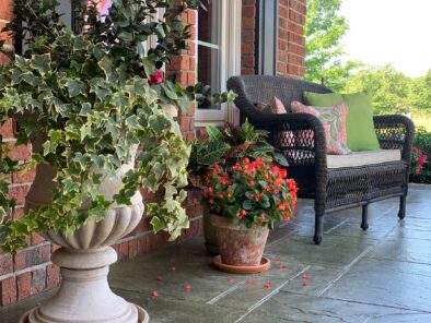 Photo of front porch with wicker loveseat and flowers