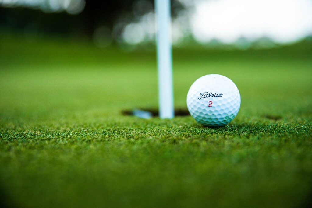 Photo of Titleist golf ball on green near hole