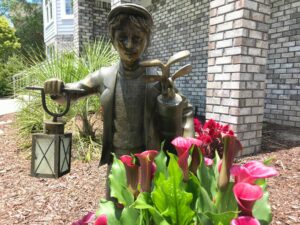 Photo of metal golf lantern statue and flowers in Maple Creek