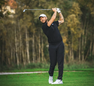 A man swinging his golf club on a golf course