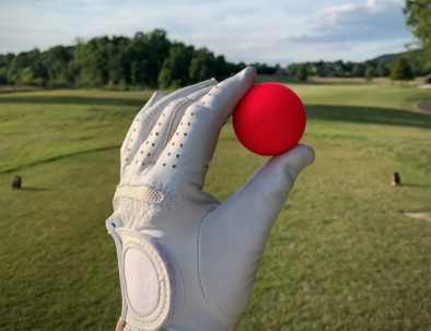 man holding a red golf ball