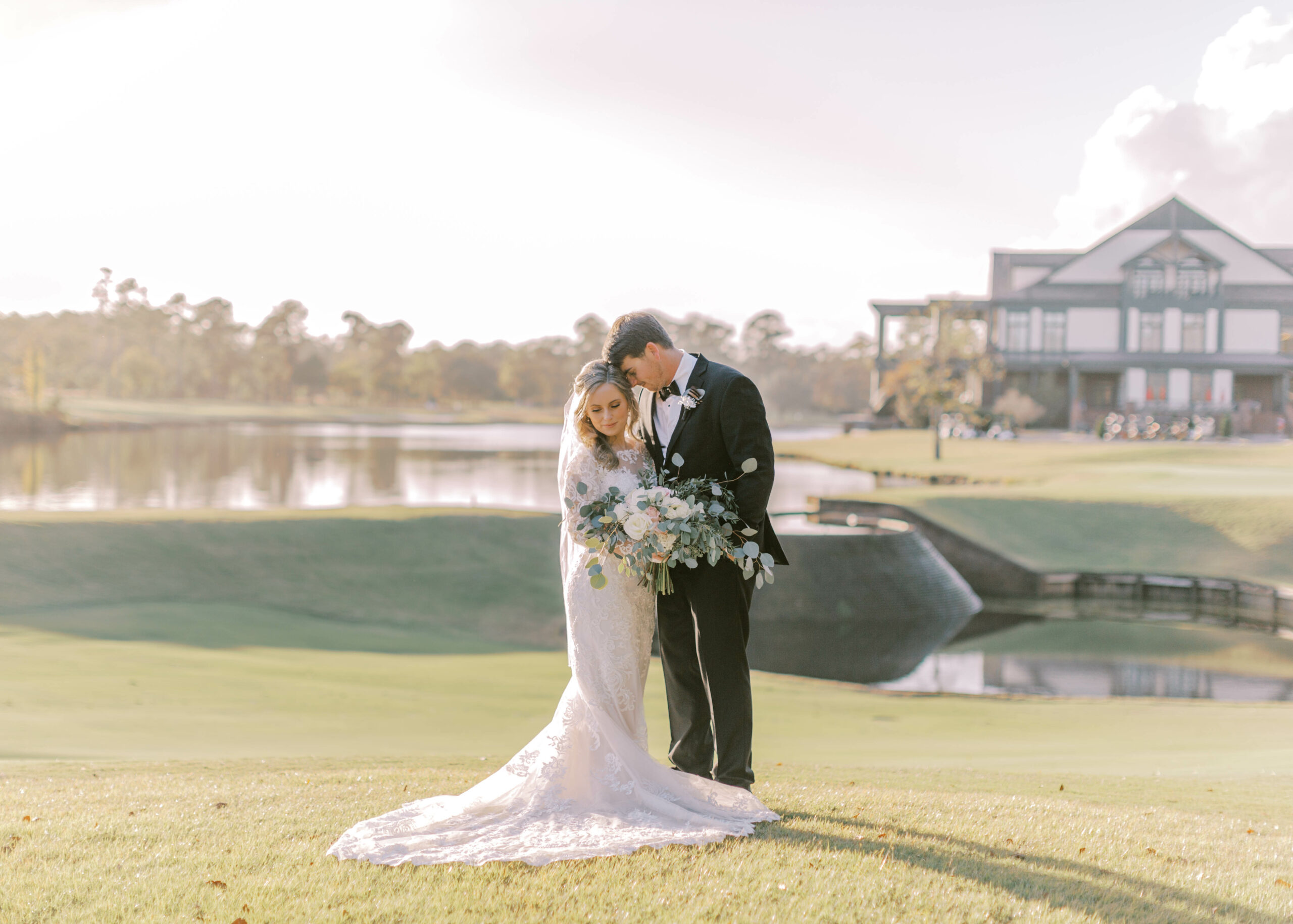 couple taking pictures with a background of golf course and clubhouse